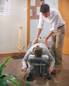 A chiropractor adjusts a patients back