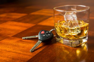 Drink or drive: that is the question, image of car keys next to a shot of whiskey on the rocks