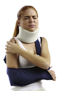 Injured woman with arm sling and neck corset