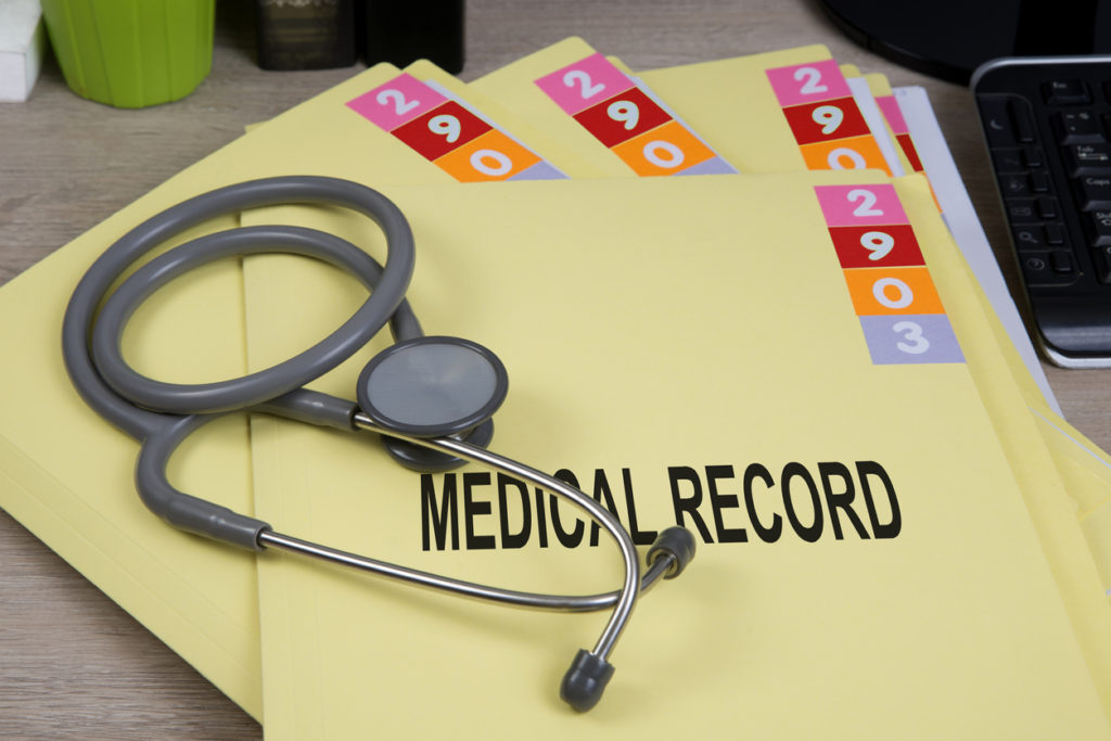Medical record folders and stethoscope on a desk