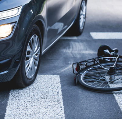 A bike on the ground next to a car