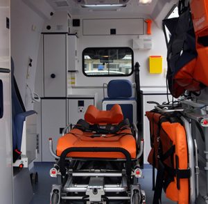 The view inside an ambulance includes a gurney and compartments for supplies and equipment