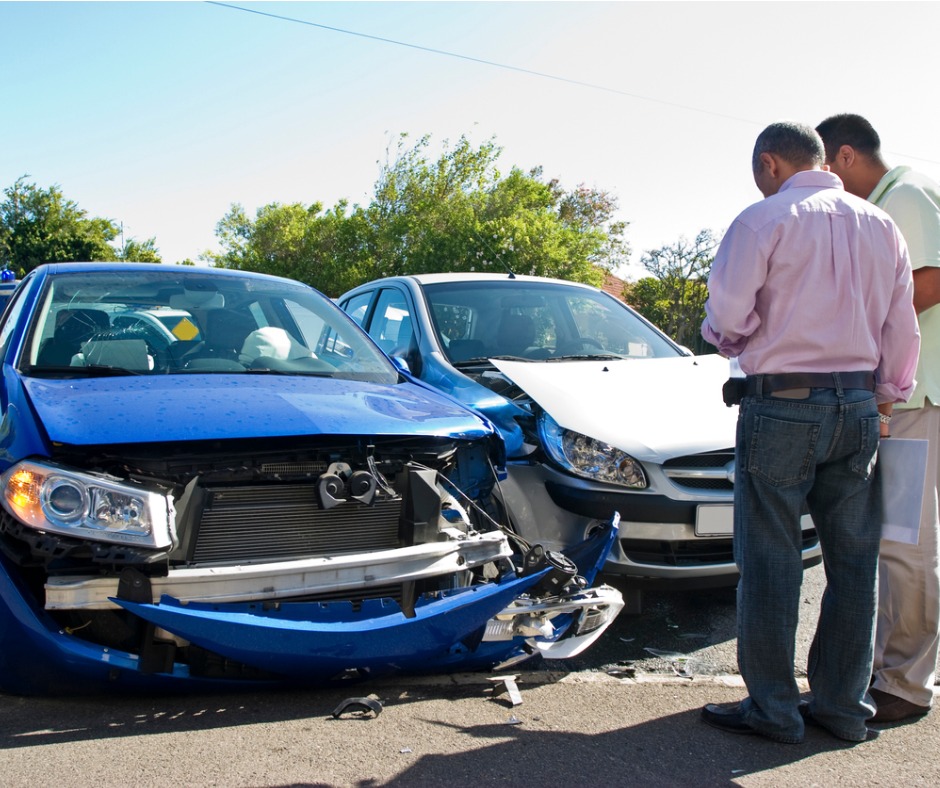 Insurance adjuster and man looking over a damaged vehicle