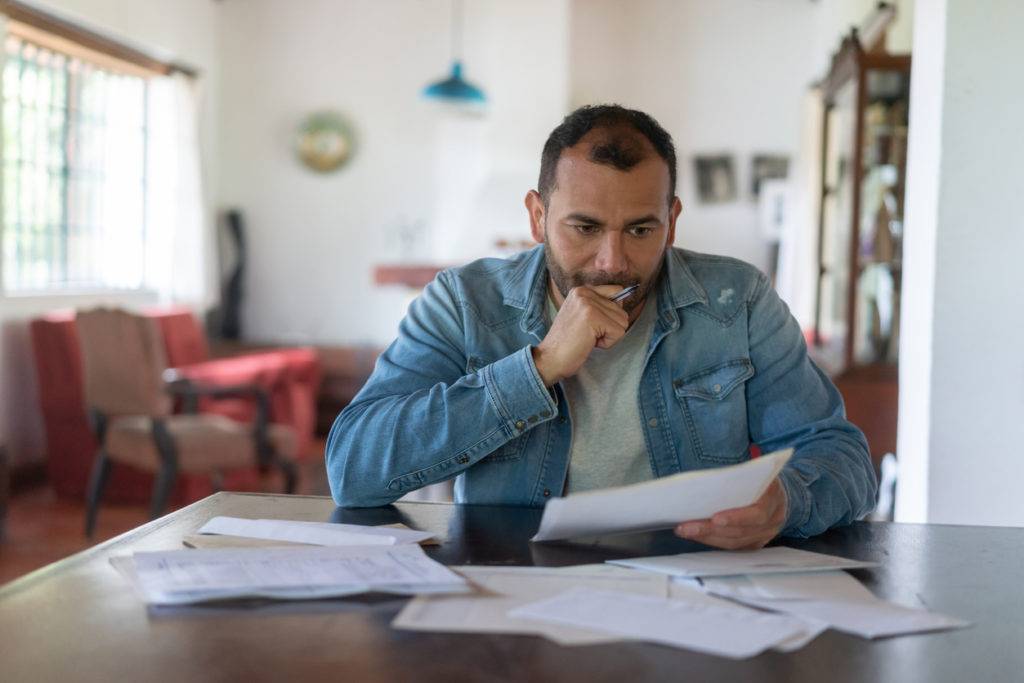 A man checking his home finances looks worried
