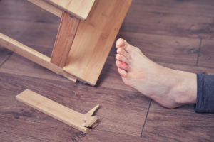 Young woman injured her foot due to falling from a broken chair