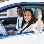 young women driving with man in passenger seat 