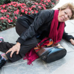Senior woman lying on floor after falling feeling pain in her leg