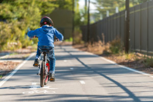 boy riding his bicycle on bike lane