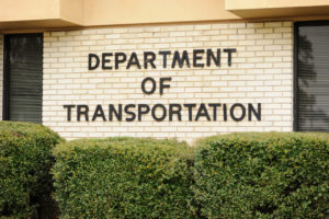 Close up photograph of department of transportation sign on building.