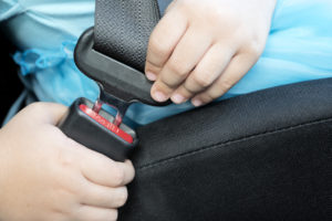 child putting on seatbelt 
