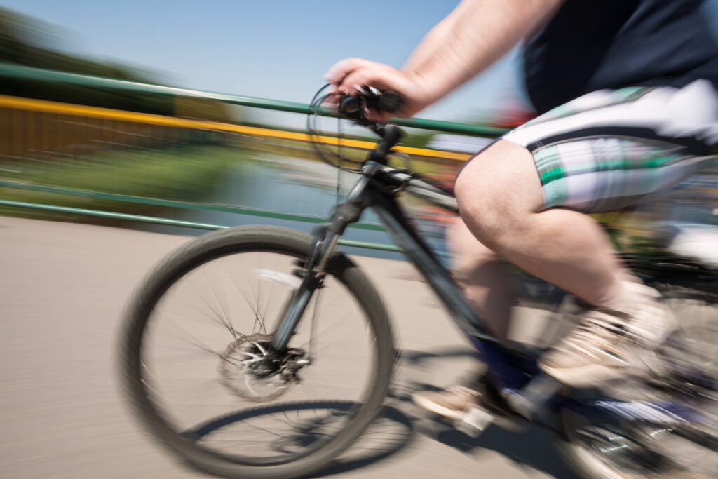 Man rides a bicycle on city streets. Intentional motion blur
