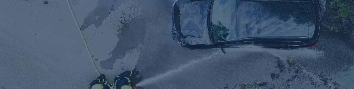 two firefighters-extinguishing a burning car